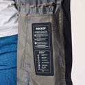 Intérieur d'une veste noire avec une étiquette RECCO et STX. La veste est imperméable, coupe-vent et respirante.