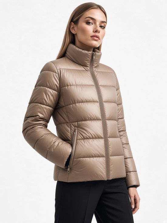 Zijaanzicht van een model in een beige pufferjas met opstaande kraag en ritssluiting.