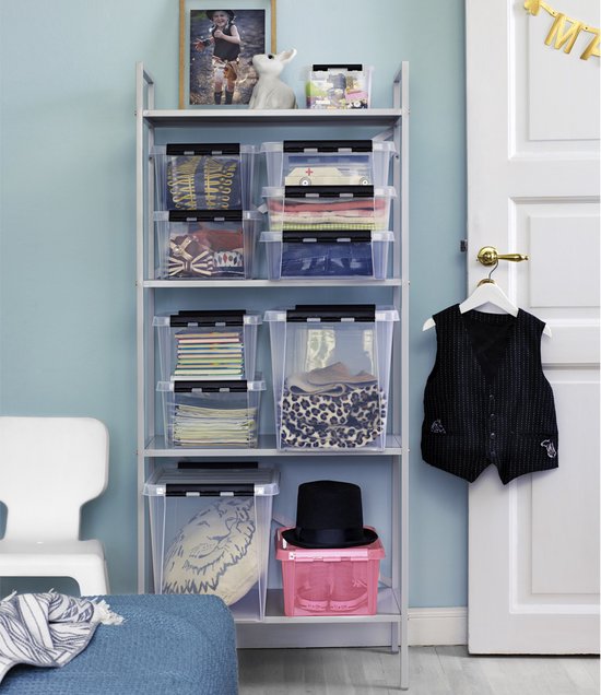 Kinderkamer met opbergrek vol met transparante boxen met kleding en speelgoed. Een roze box met hoed.