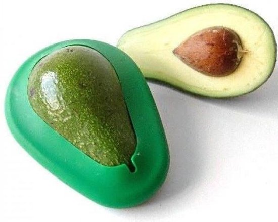 Een halve avocado met pit naast een groene bewaardoos waarin een hele avocado past.