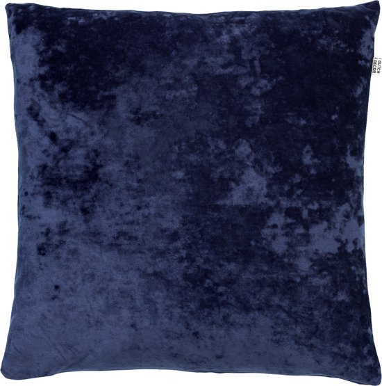 Een donkerblauw, fluwelen sierkussen met een label 'DUTCH DECOR'.