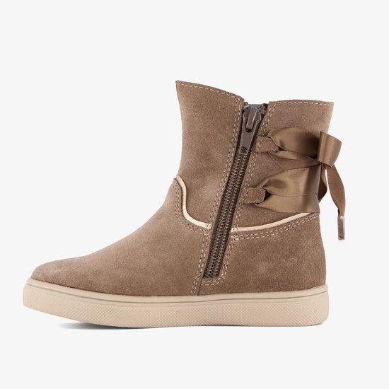Zijkant van beige suède enkellaarsjes met rits en strikjes aan de achterkant.