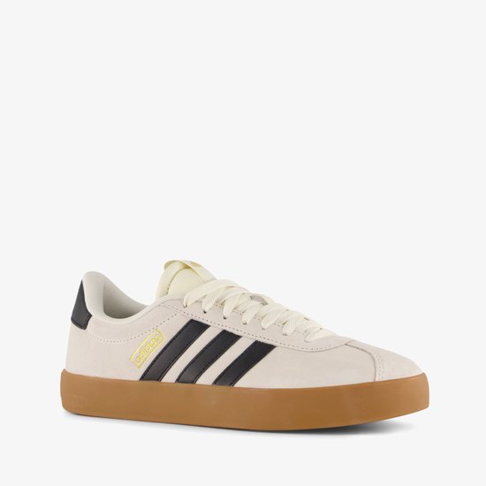 Baskets Adidas beige clair avec rayures noires, logo doré 'adidas' et semelle en gomme.