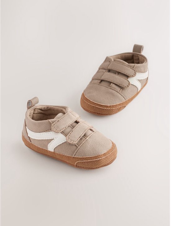 Twee bruine suède babysneakers met witte strepen en klittenbandsluiting.