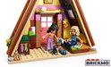 Interieur LEGO Friends Glamping Cabin met twee minipoppen, een zwarte kat en een bed.