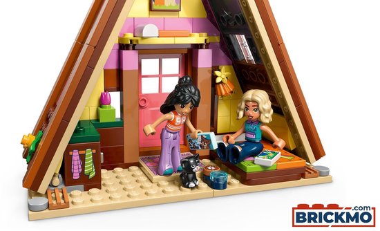 Interieur LEGO Friends Glamping Cabin met twee minipoppen, een zwarte kat en een bed.