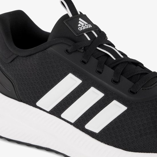 Close-up van de zijkant van een zwarte Adidas sneaker met witte strepen.