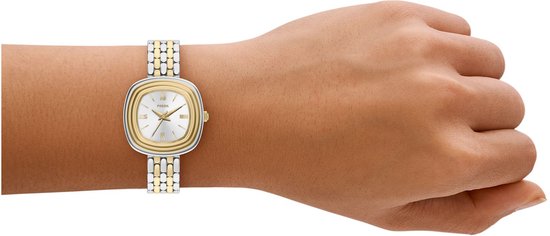 Een Fossil dameshorloge met een tweekleurige (zilver en goudkleurig) band om een pols.