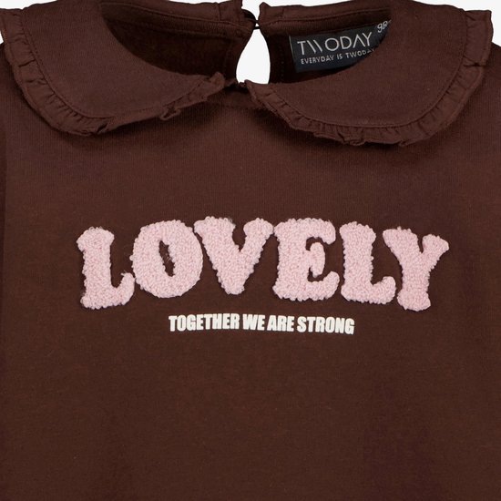 Detail van bruine sweater met ruche kraag en roze tekst 'LOVELY'.