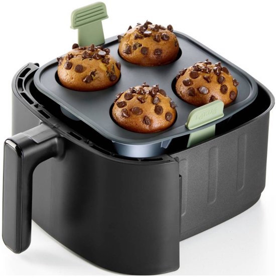 Grijze siliconen bakvorm met 4 ronde uitsparingen, gevuld met vier chocolademuffins, geplaatst in een zwarte heteluchtfriteuse.