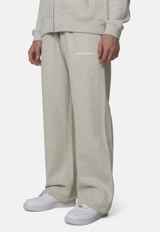 Zij-aanzicht van een grijze 'GOODFORNOTHING' joggingbroek met logo op de heup.