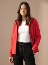 Vrouw in rood sportvest met rits en kap, witte top, zwart met ruitpatroon.