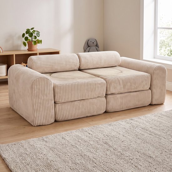 Beige corduroy bank met een zacht plaid en een teddybeer.