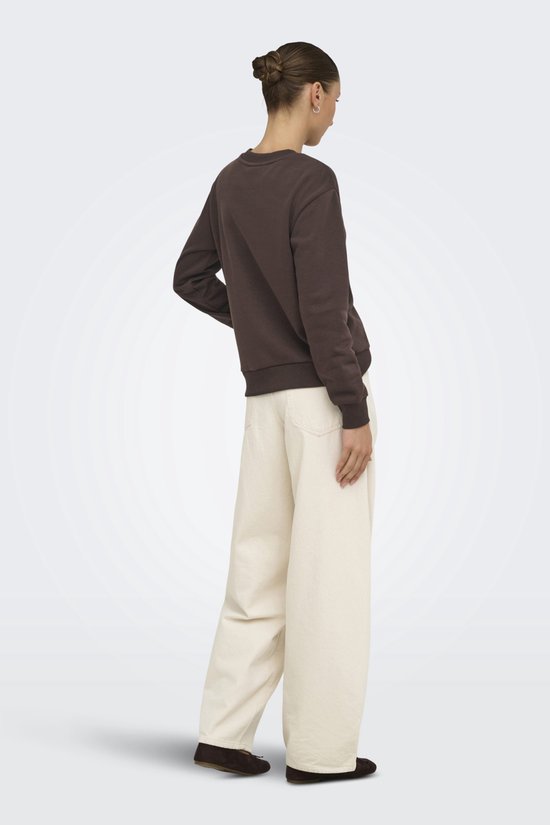 Model van achteren gezien in bruine sweater en wijde beige broek.