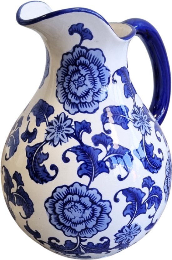 Witte schenkkan met veel blauwe bloemen en bladeren, smalle tuit, gebogen handvat.