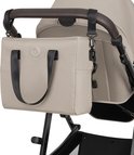 Beige verzorgingstas aan de duwstang van een kinderwagen.