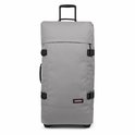 Grijze Eastpak Tranverz L reiskoffer met zwarte gespen en handvat.