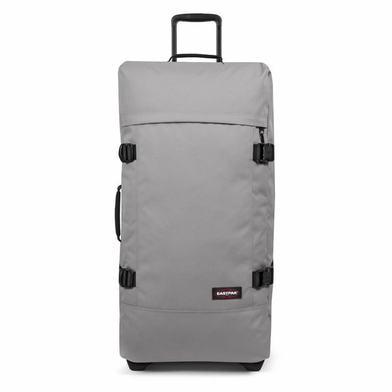 Grijze Eastpak Tranverz L reiskoffer met zwarte gespen en handvat.