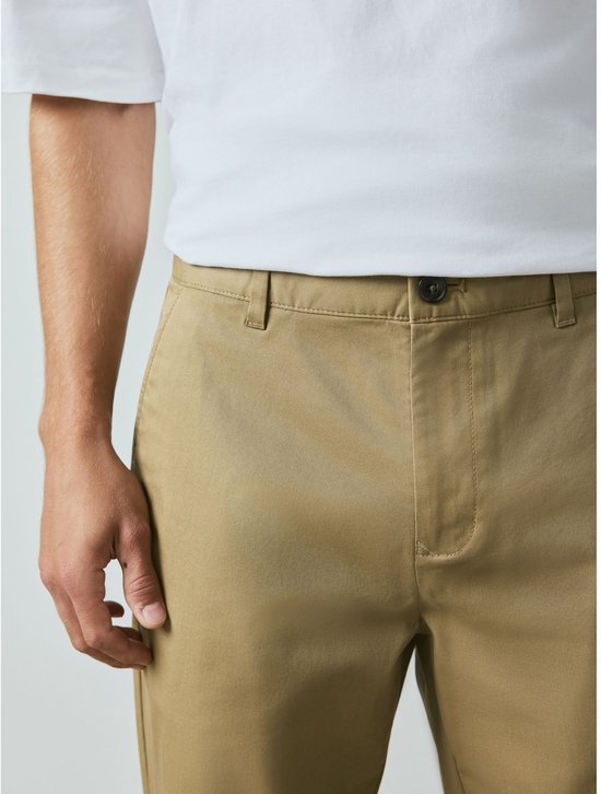 Close-up van man's tailleband van zandkleurige chino met knoopsluiting