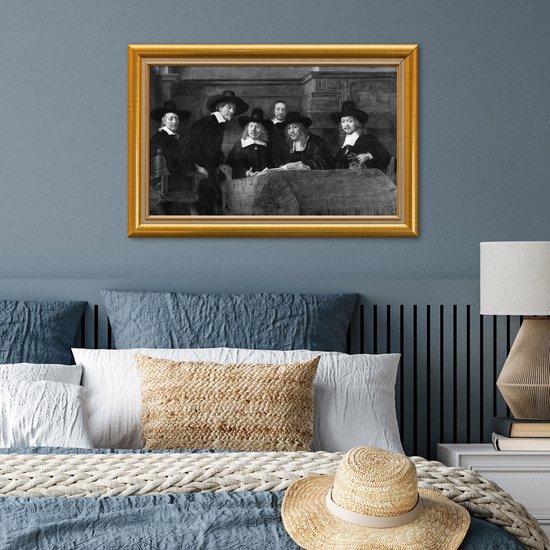 Een groep mannen in klederdracht met hoeden staat rond een tafel, ingelijst in een gouden lijst.