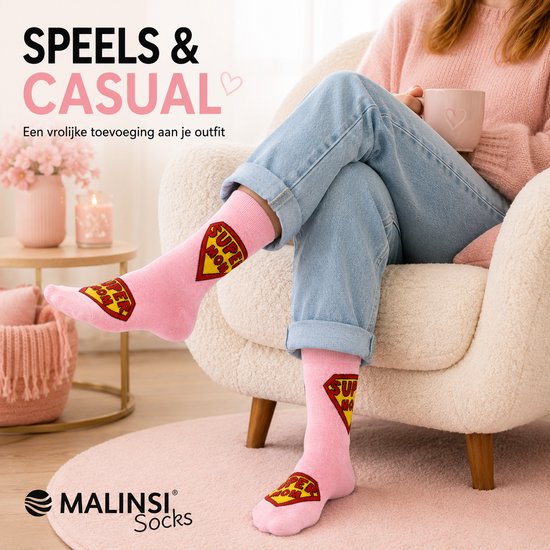 Vrouw in beige fauteuil met jeans en roze sokken met 'SUPER MOM' logo.