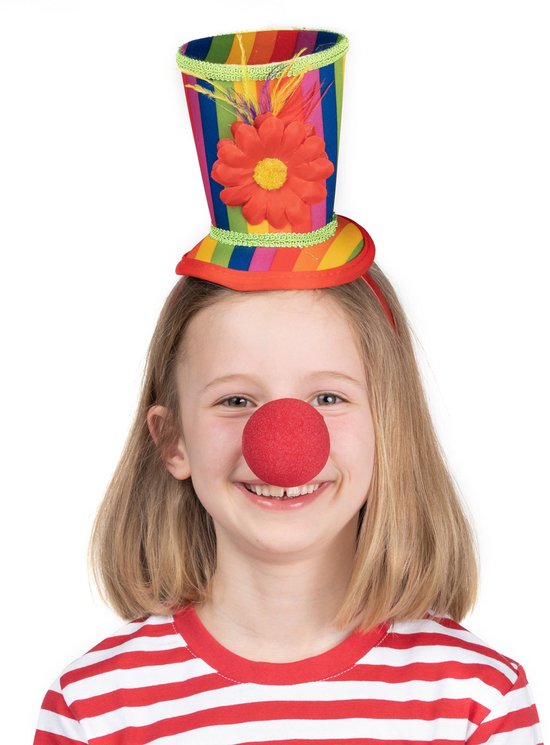 Meisje met blonde haren met een rode clownsneus en een hoge, veelkleurige clownshoed met een bloem en veren.