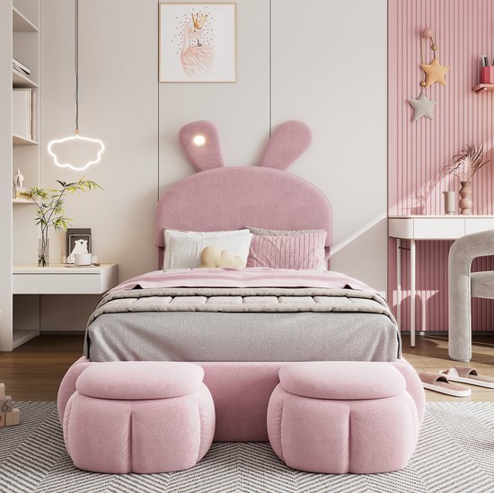 Roze kinderbed met konijnenoren, LED-lampjes en twee opbergkrukjes aan het voeteneind.