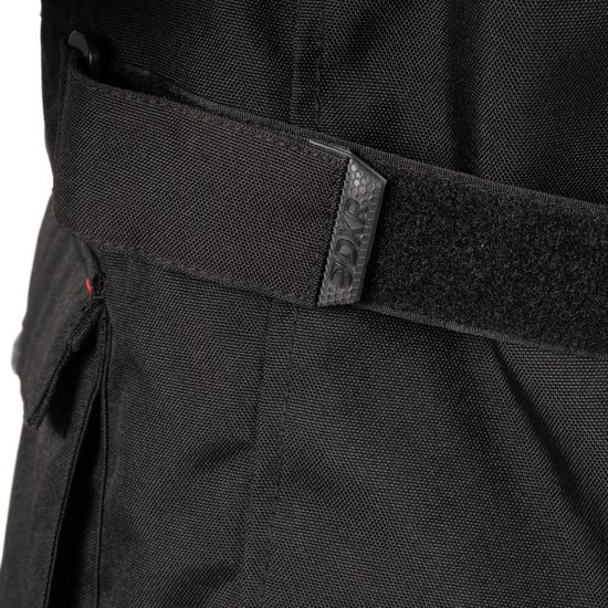 Detail van de zwarte motorjas met verstelbare band en klittenbandsluiting. Logo: "DYR".