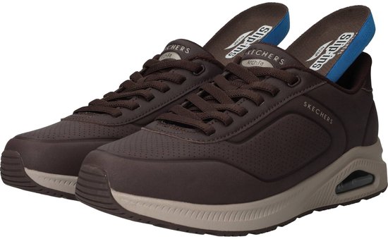 Een paar donkerbruine Skechers sneakers met uitneembare Arch Fit zolen.