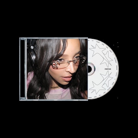 CD met Popstar-logo en sterren, naast een open hoesje met een close-up van een vrouw met een roze top en glimmende bril.