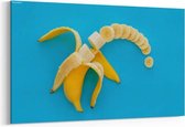 Schilderij - Slices of banana on bright blue paper — 90x60 cm