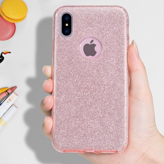 Hand met een roze glitter telefoonhoesje met Apple logo.