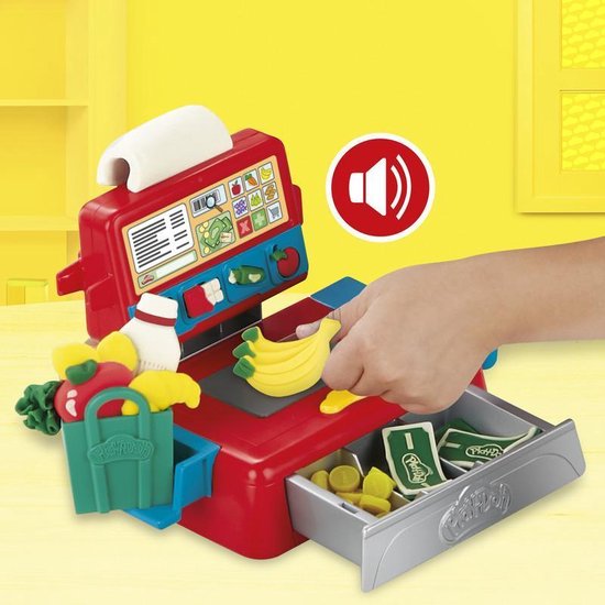 Een hand opent de lade van een rode en blauwe speelgoedkassa, met Play-Doh geld en munten.