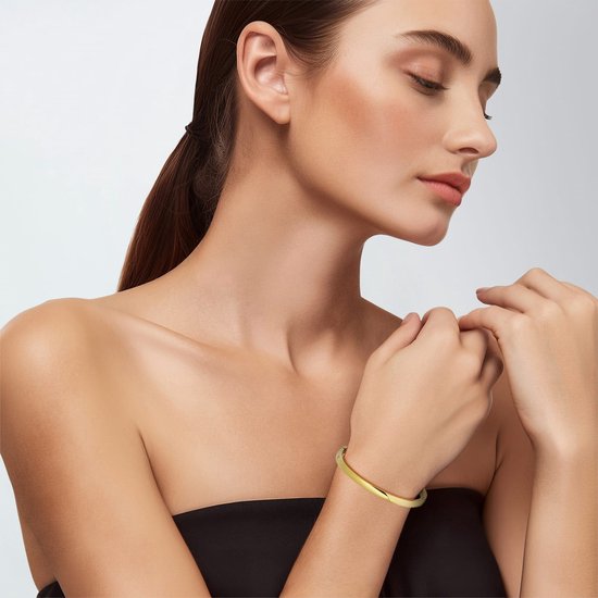 Model met gesloten ogen draagt een gouden bangle armband, 5 mm breed.