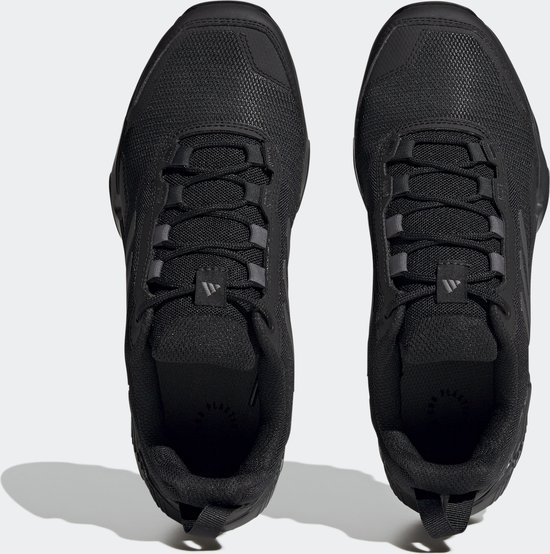 Zwarte lage wandelschoenen, gezien van bovenaf, met veters en Adidas-logo op de neus.