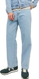 Man in een lichtblauwe jeans en een denim jack, met groene sneakers.