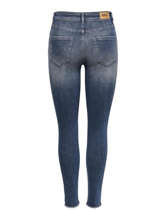 Achterkant van een vrouw in een lichtblauwe skinny jeans met rafelige zoom.