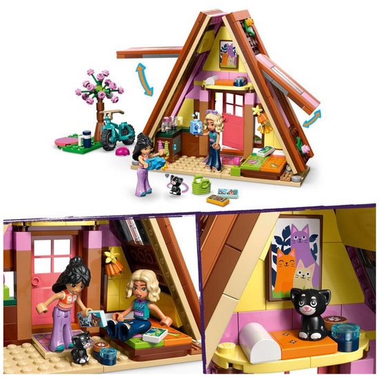 Lego Friends speelgoedhuisje met roze accenten, fiets en poppetjes. Close-up van het interieur met twee poppetjes en een kat op een schilderij.