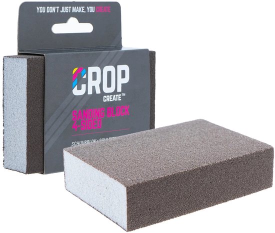 Een grijs schuursponsje met een schuurlaag aan vier zijden. De verpakking met "CROP CREATE" logo ligt erachter.