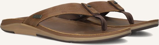 Twee bruine leren Reef teenslippers, van de zijkant bekeken, met suède bandjes.