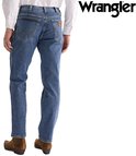 Achterkant van een spijkerbroek met een lichtblauwe wassing, gecombineerd met bruine laarzen en een wit overhemd.
