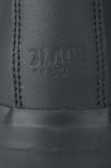 Close-up van reliëf logo op achterkant zwarte sneaker.