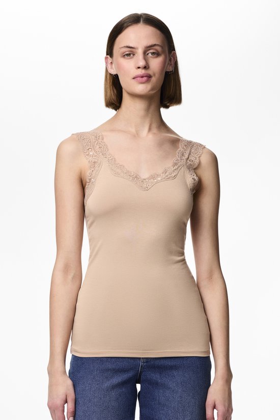 Model in beige hemd met kanten rand, gedragen met spijkerbroek.