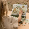 Meisje speelt met magnetisch safari speelbord, met dieren zoals leeuw, giraf, zebra en olifant.