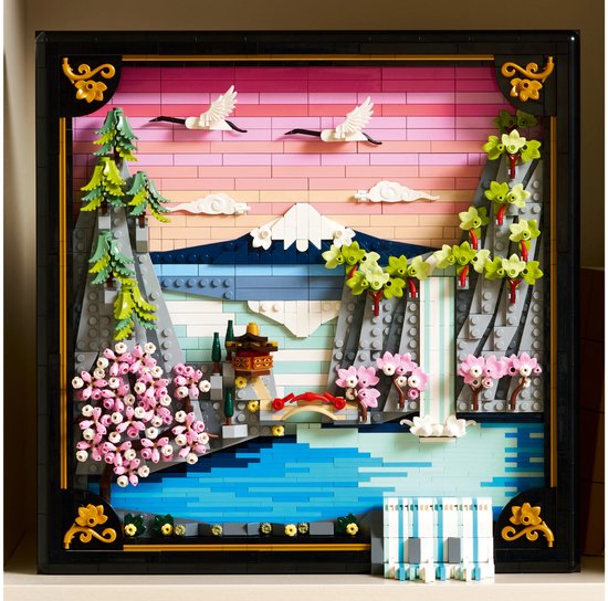 LEGO-landschap met berg, waterval, kersenbloesems en kraanvogels bij zonsondergang in een zwart kader.