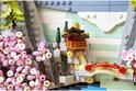 Gedetailleerd LEGO-model van een Japanse lantaarn en bloeiende kersenbloesems tegen een rotsachtige achtergrond.