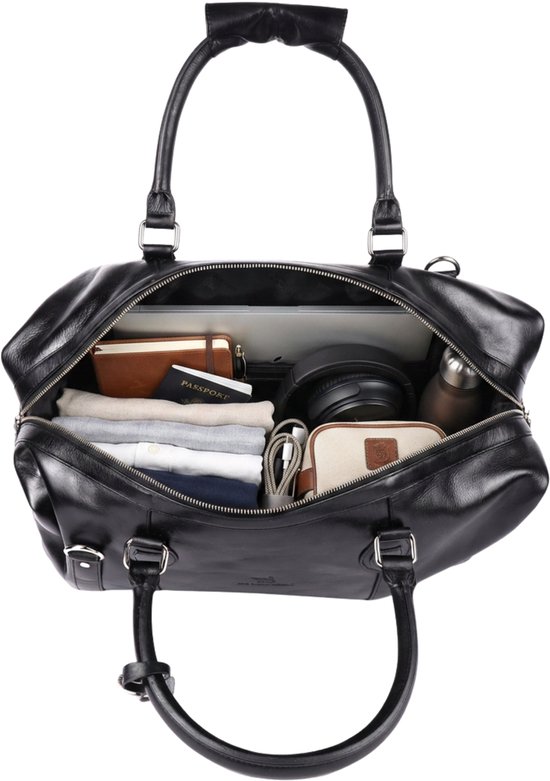 Open zwarte leren reistas gevuld met kleding, een laptop, koptelefoon en paspoort.