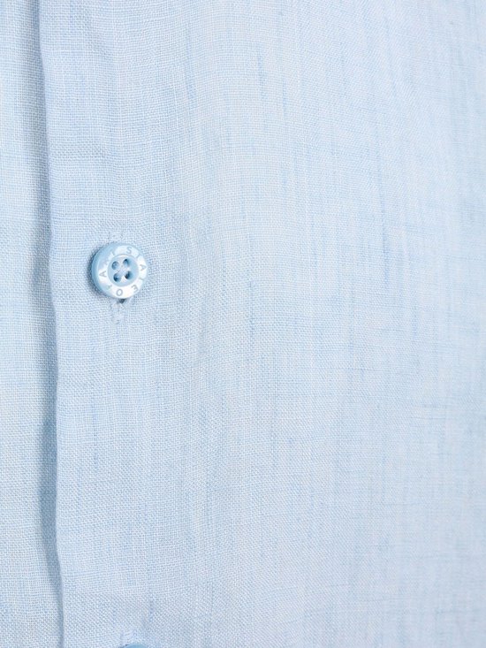 Detail van een lichtblauwe linnen stof met een knoop met het 'State of Art' logo.