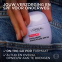 L'Oréal Revitalift Hyaluron Aqua-Fluid SPF30 in een paars flesje, in een jeanszak.
