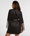 Model met lang bruin haar, achterkant van zwarte satijnen kimono met kanten mouwen